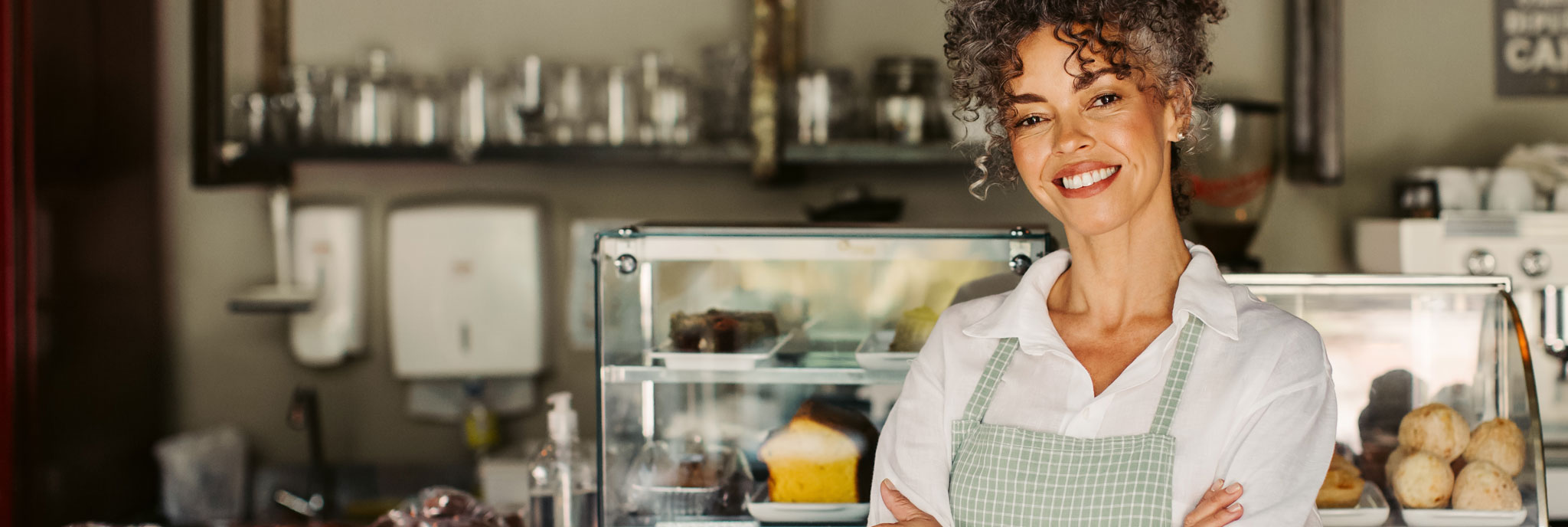 A smiling bakery owner standing behind her counter