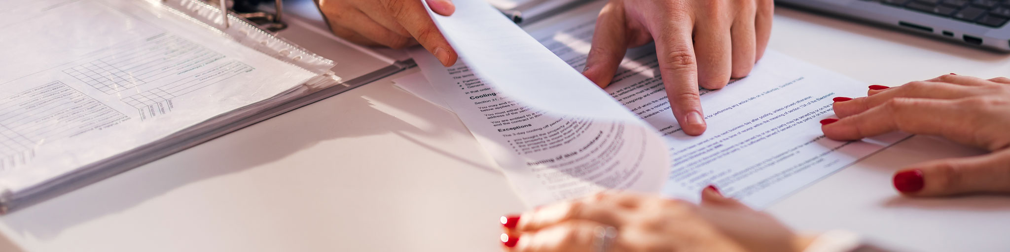 Hands reviewing loan paperwork at a desk
