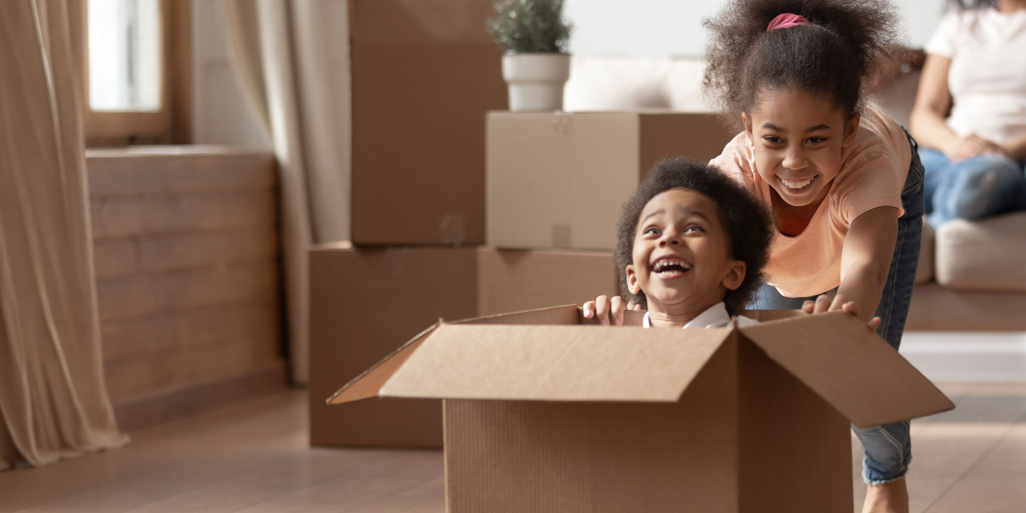 A family sitting together surrounded by moving boxes